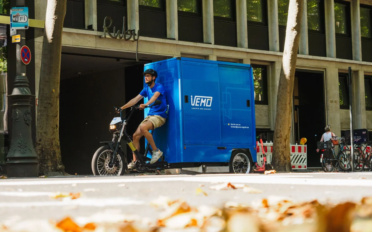 VEMO-Fahrer mit geschlossenem Lastenrad unterwegs in Bonn