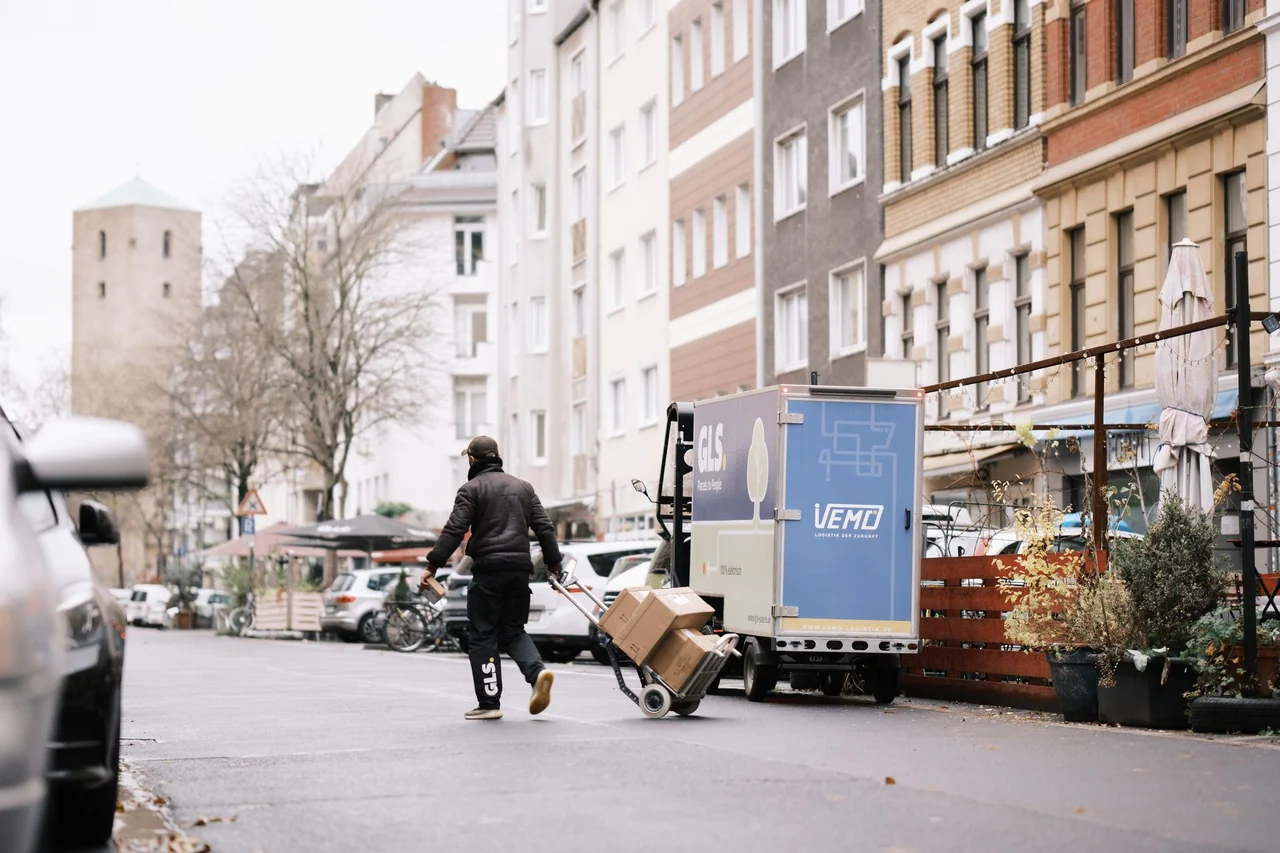 VEMO-Fahrer zieht Umzugskartons auf einer Sackkarre zum Lastenrad