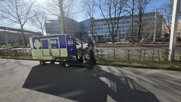 GLS-Lastenrad mit Anhänger vor Bürogebäuden