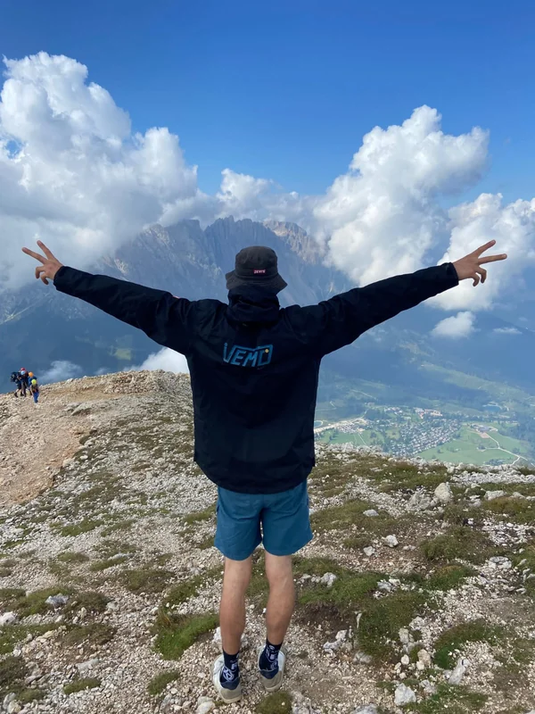 Kollege im VEMO-Pullover auf einem Berggipfel